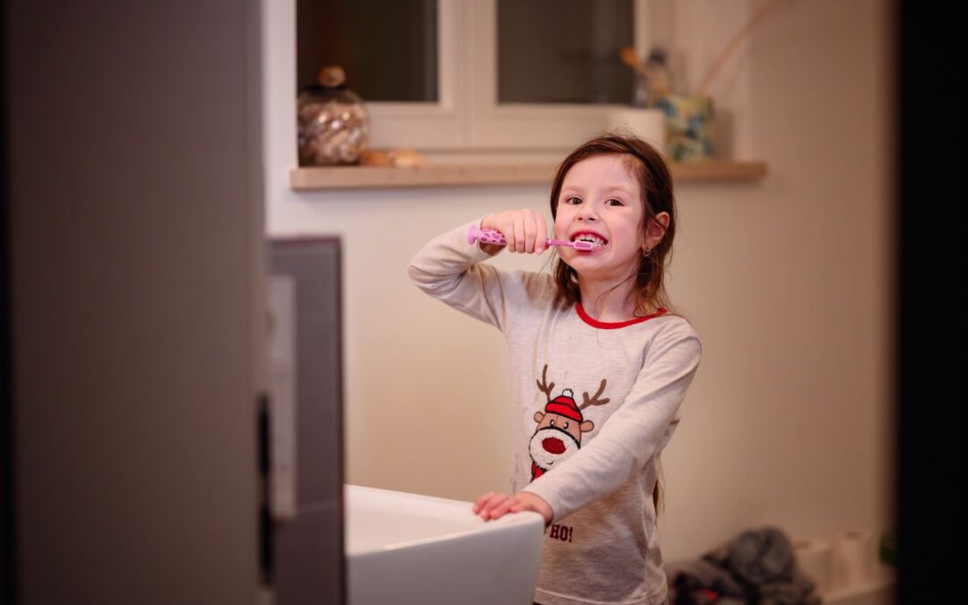 Child happily brushing teeth with a colorful toothbrush.